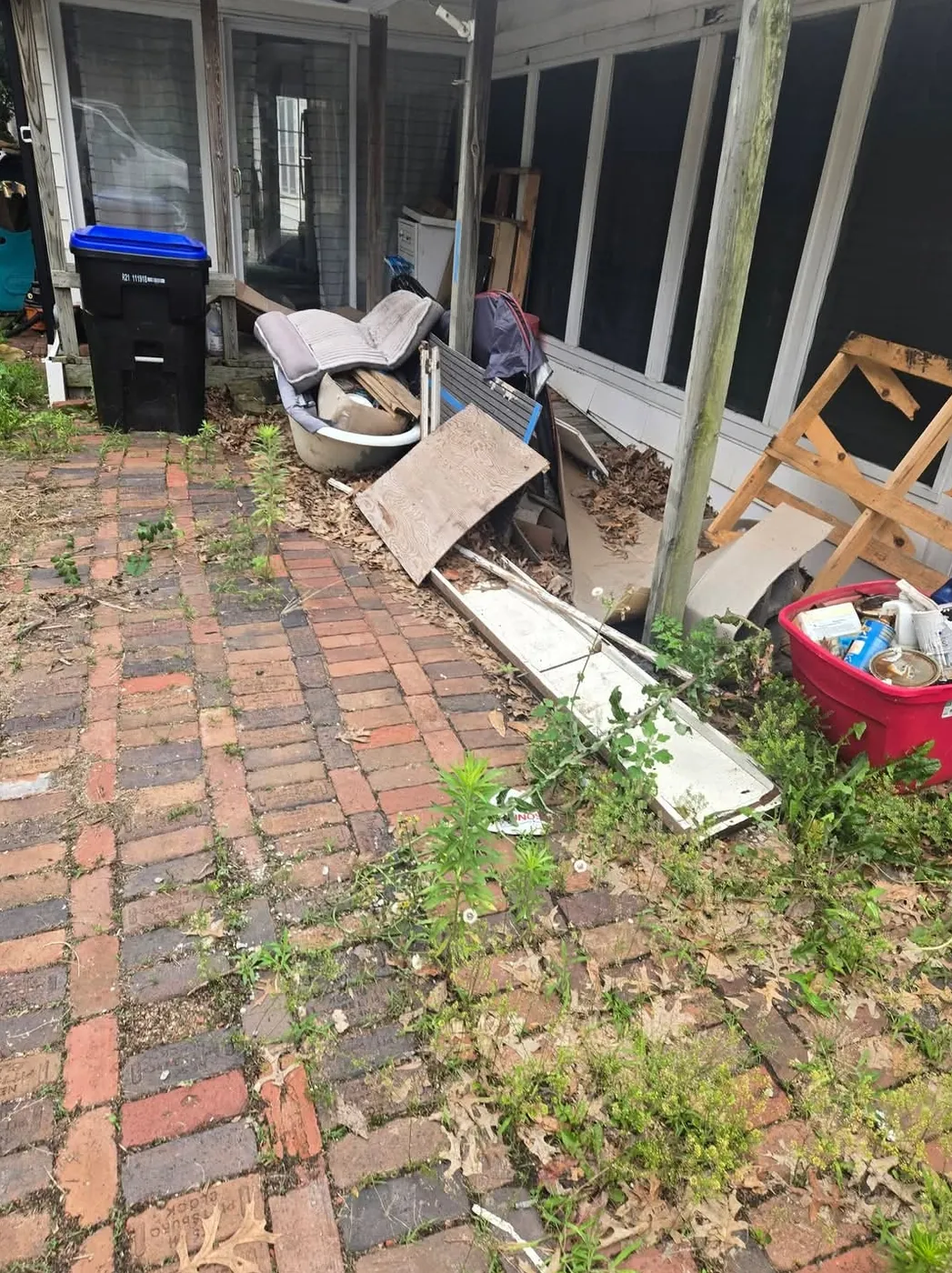 Junk and debris piled on a brick patio before a clean-out