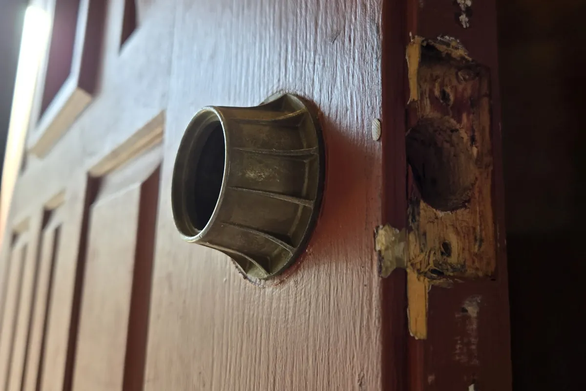 Deadbolt on a door with a worn jamb, ready for repair