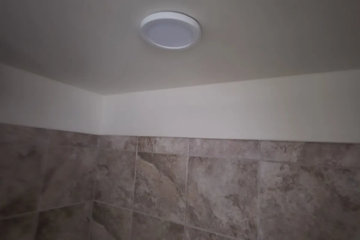 Tiled shower wall below a new ceiling light