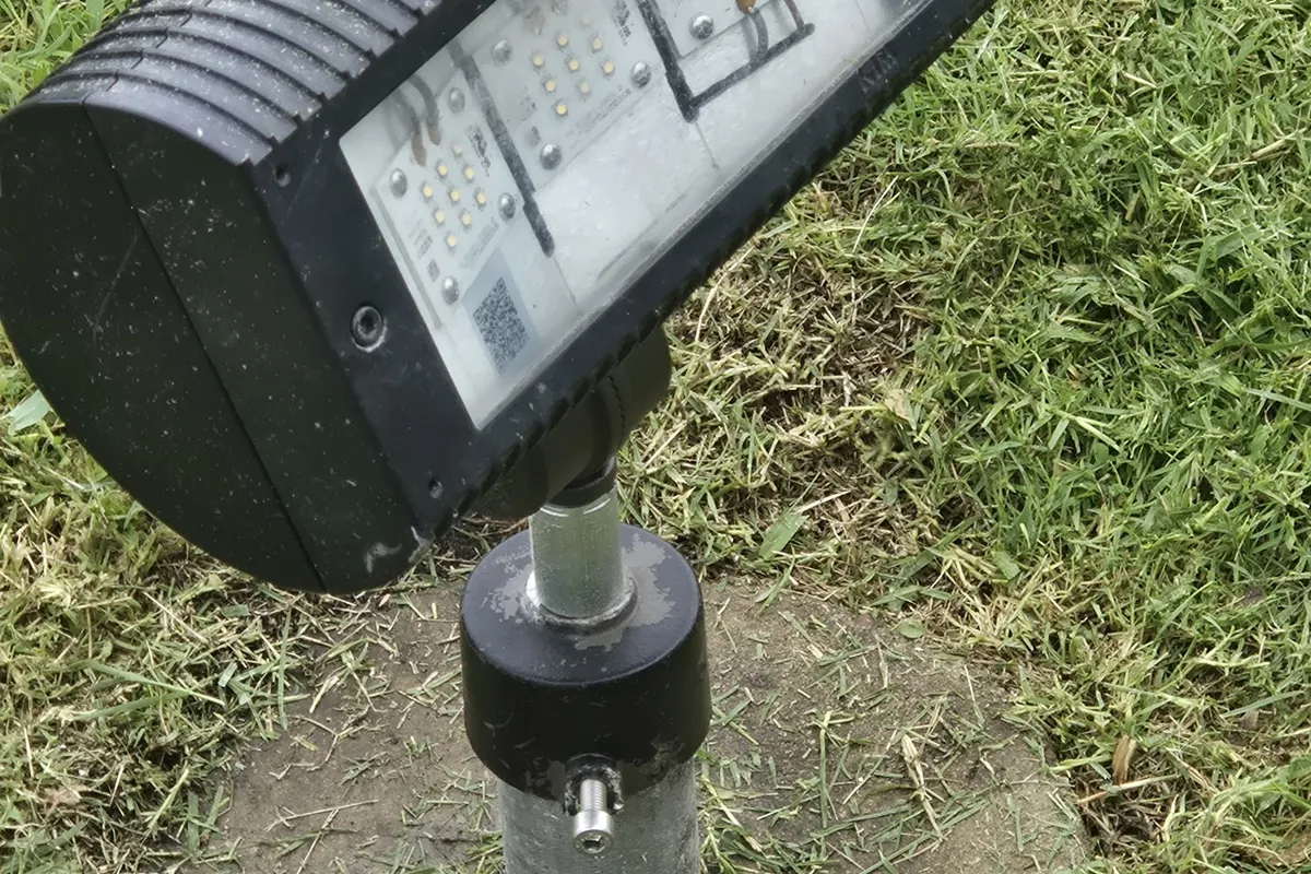 Flood light mounted on a metal post in a yard