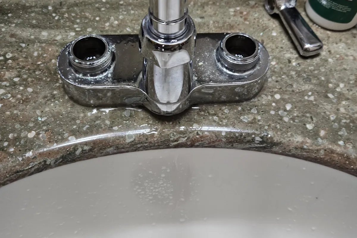 Worn two-handle bathroom faucet before repair