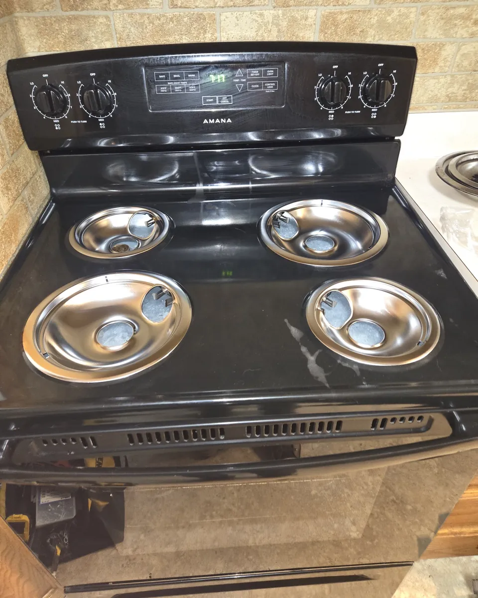 Electric range with new chrome drip pans installed