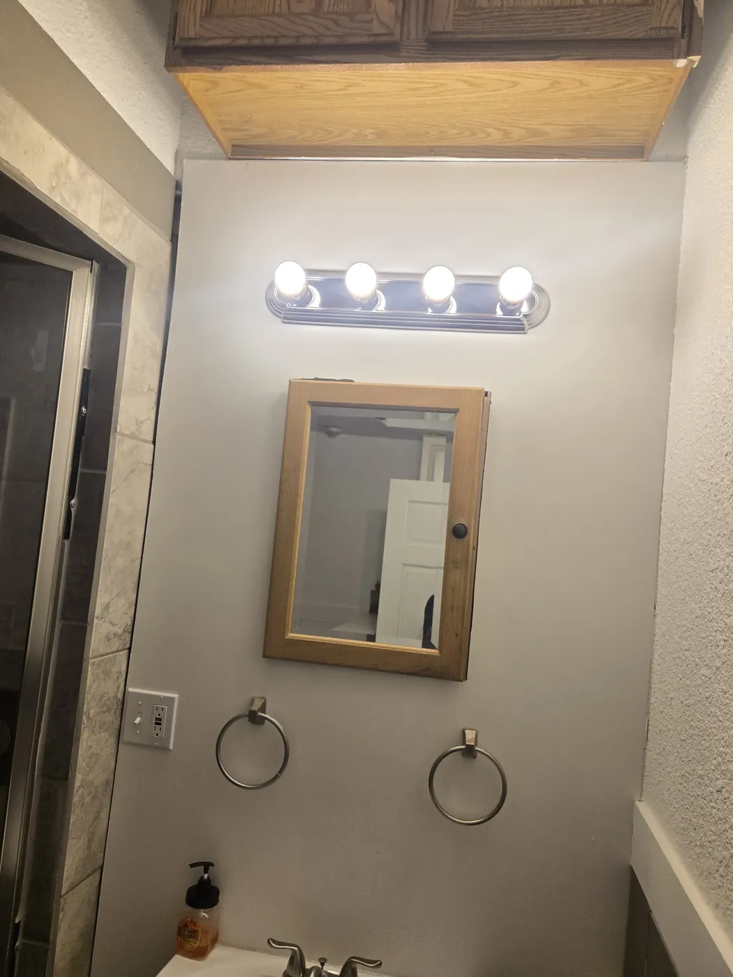 Finished bathroom with a vanity light bar and mirror cabinet