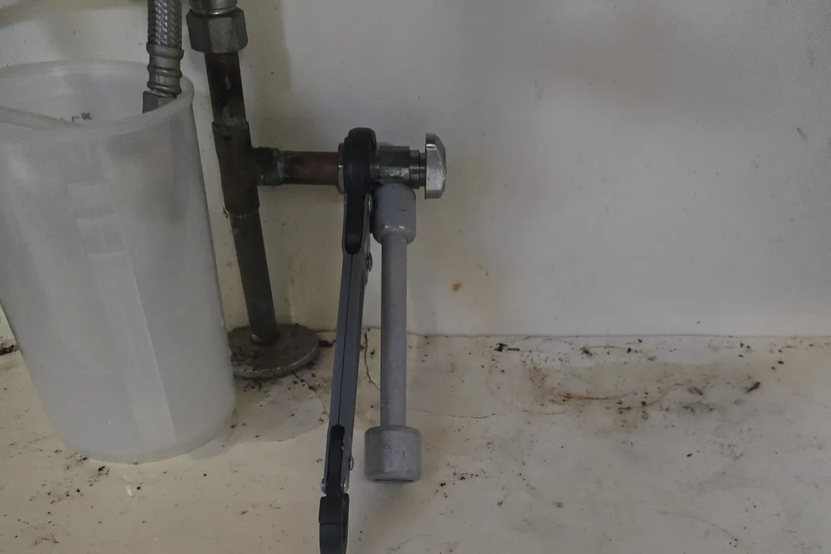 Old angle stop valve under a sink before replacement