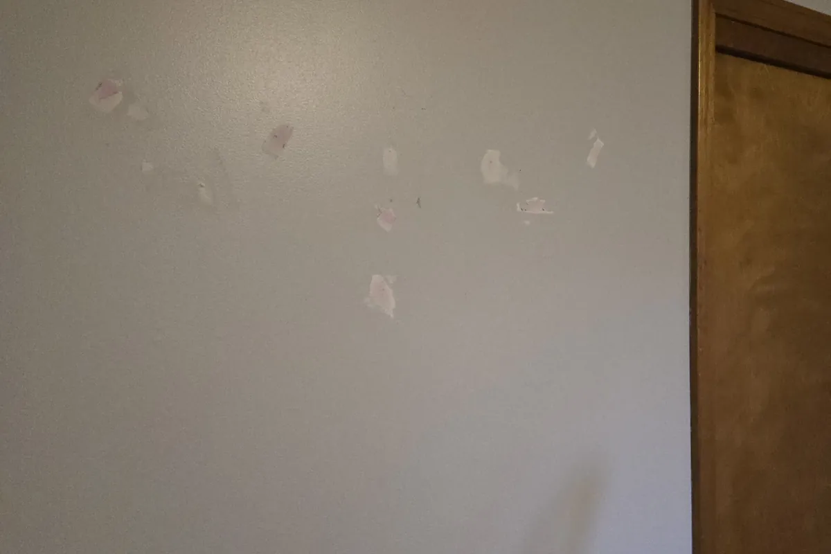 Spackled drywall patches on a wall beside a door frame