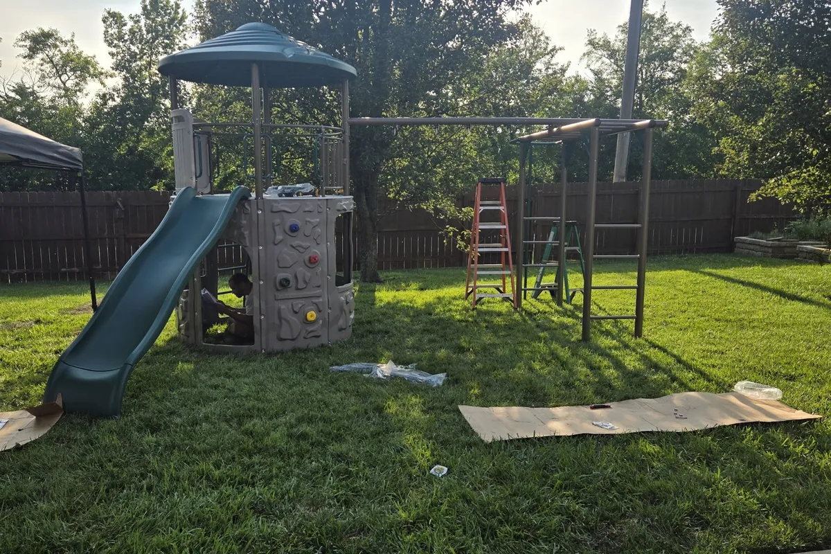 Assembled backyard playset with a metal swing frame