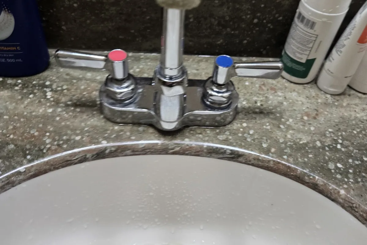 Bathroom faucet with new handles on a granite vanity