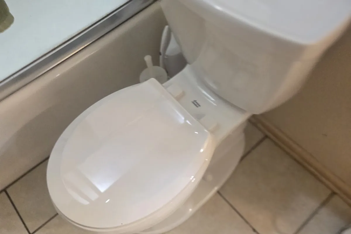 New white toilet installed on a tile floor