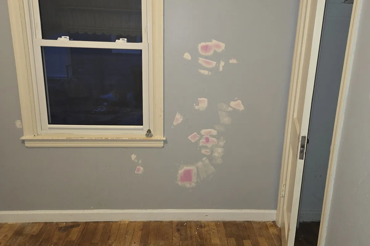 Patched drywall in a vacant rental bedroom, ready for paint