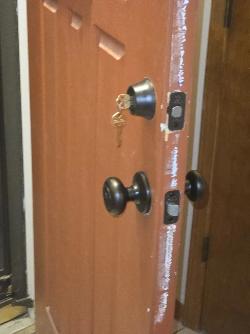 Front door with a new bronze deadbolt and knob installed