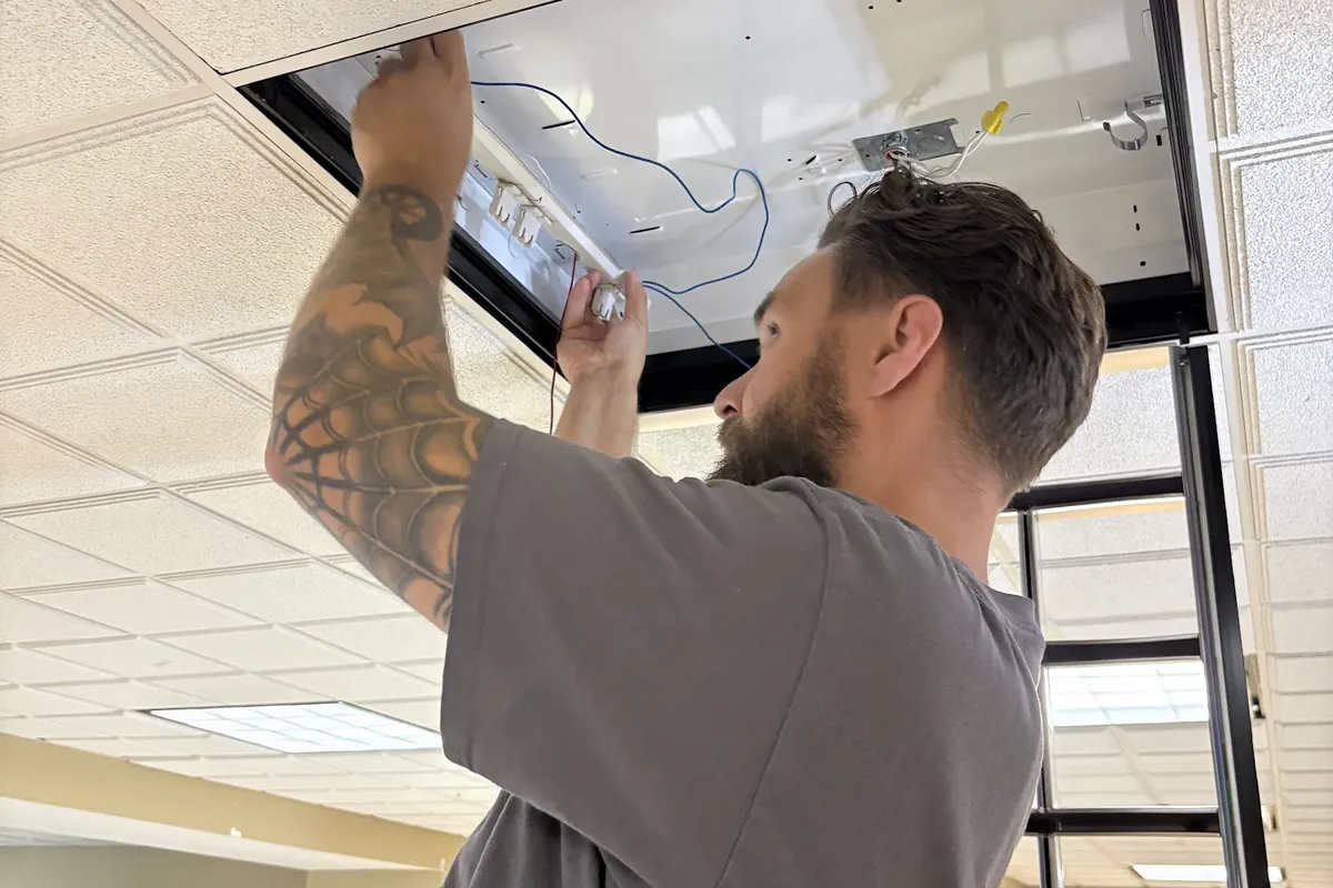 Justin replacing an office ceiling light fixture
